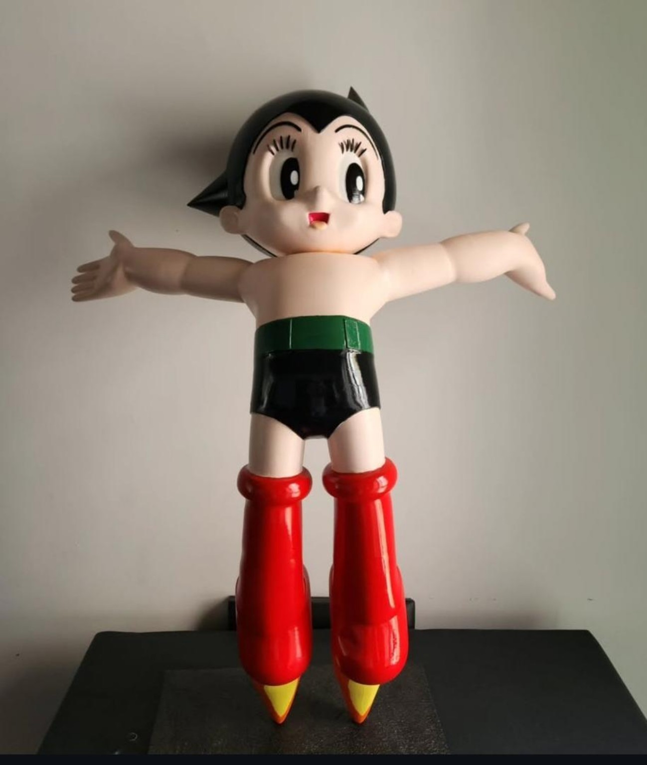 Escultura pintada de Astro Boy con brazos extendidos